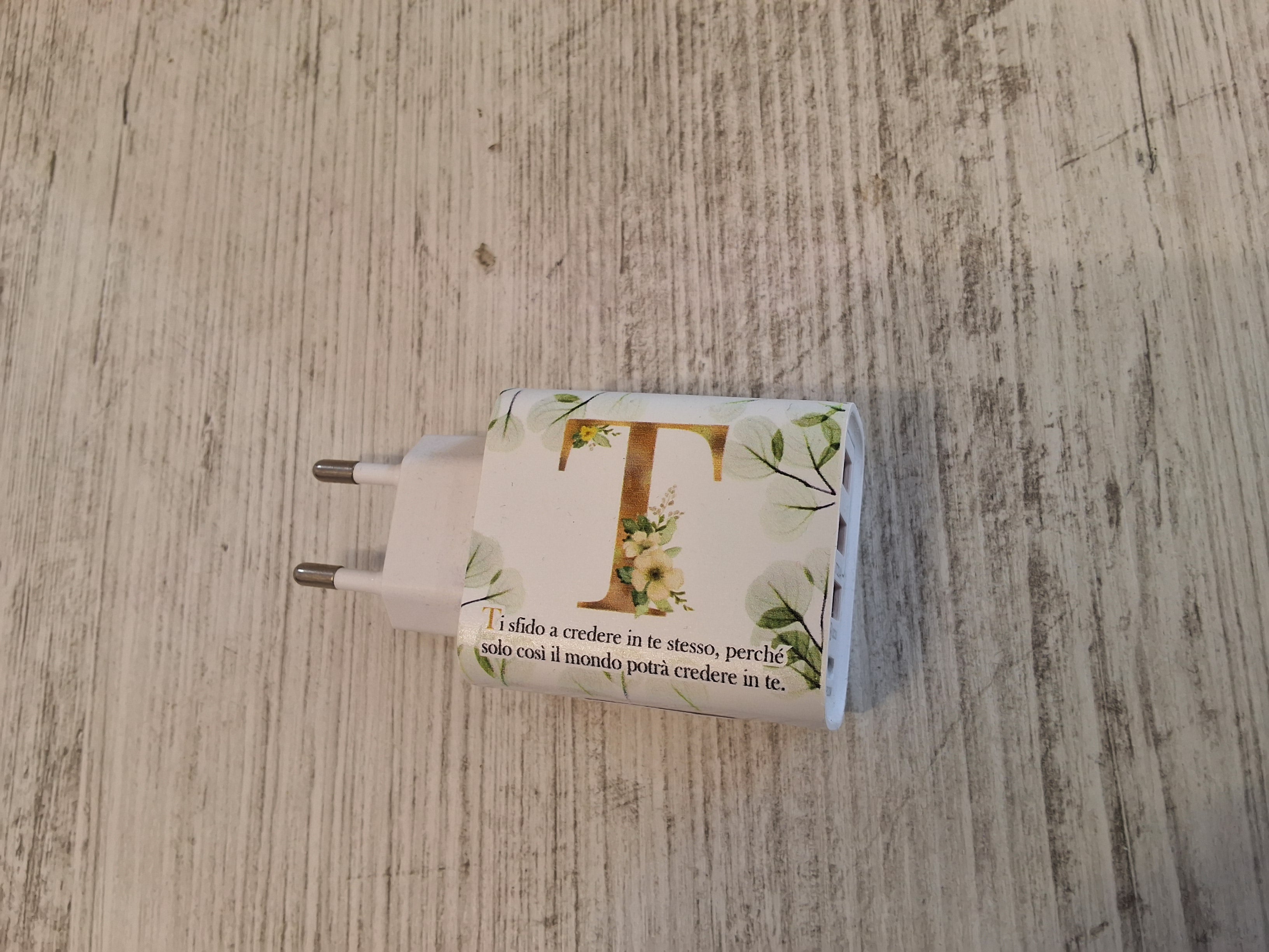 Carica batteria con iniziale T mis.9×4,7.Con l'articolo è compreso la scatola e l'astuccio porta confetti