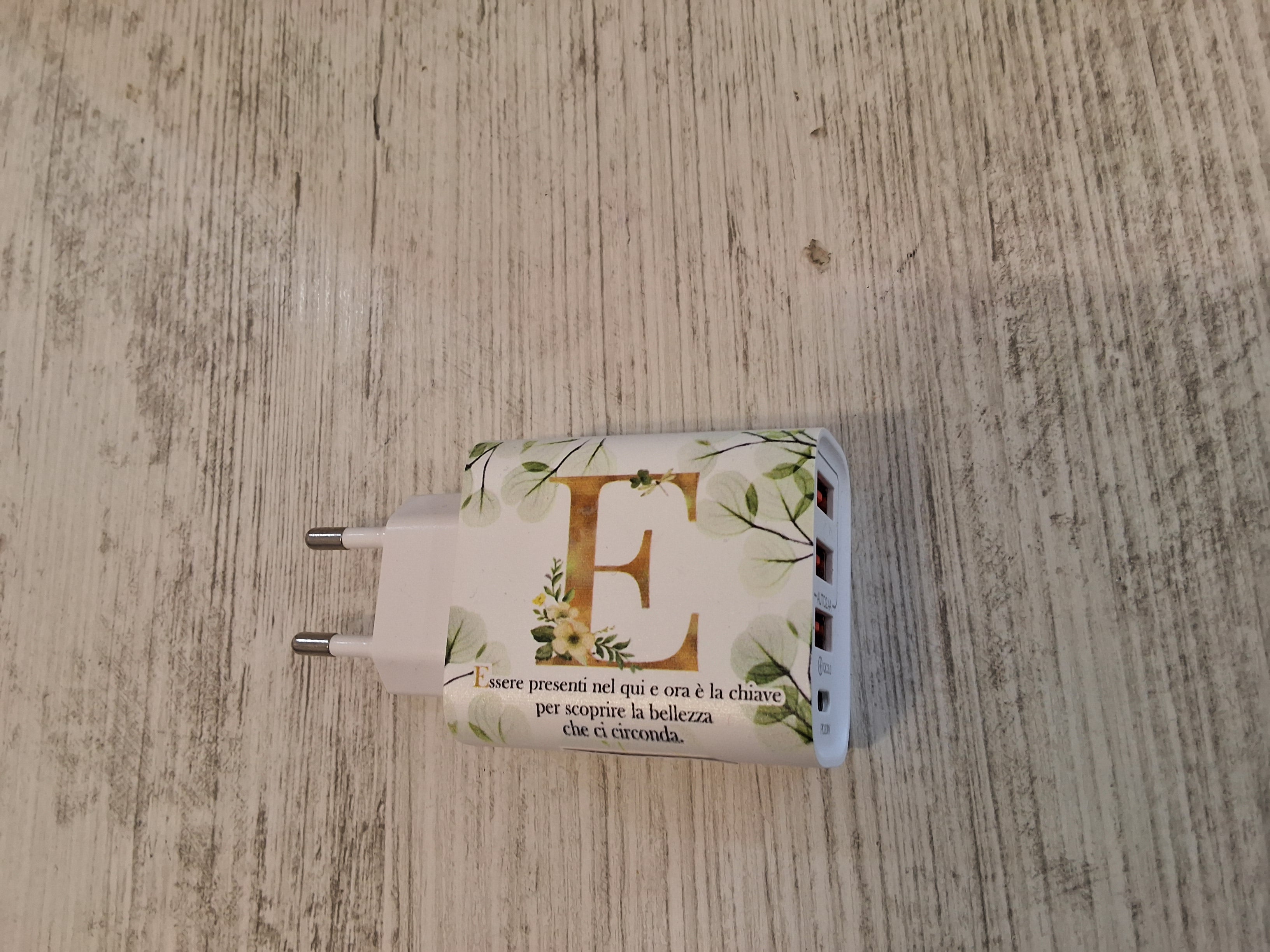 Carica batteria con iniziale E mis. 9×4,7.Con l'articolo è compreso la scatola bianca e l'astuccio porta confetti