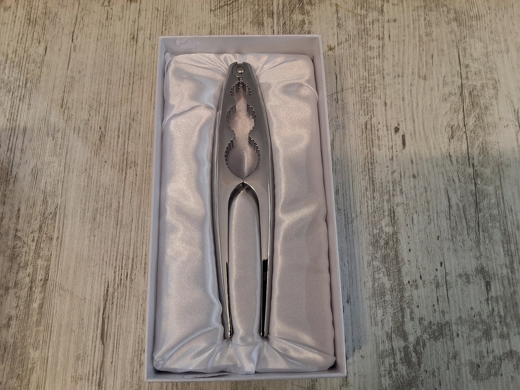 Schiaccianoci in acciaio.Mis.18×4.Con l'articolo è compresa la scatola bianca e il sacchetto cellophane porta confetti